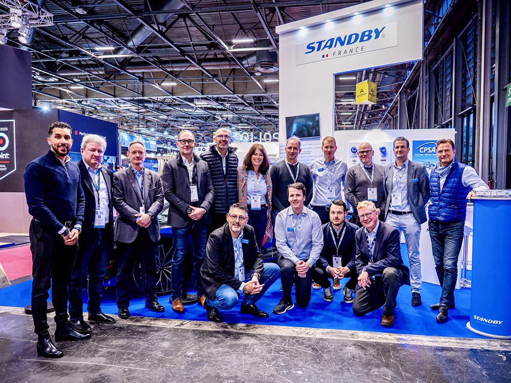 Group shot of various Standby Group employees (back row standing and the front kneeling), on the Standby France / Standby Group stand at Milipol Paris 2025.