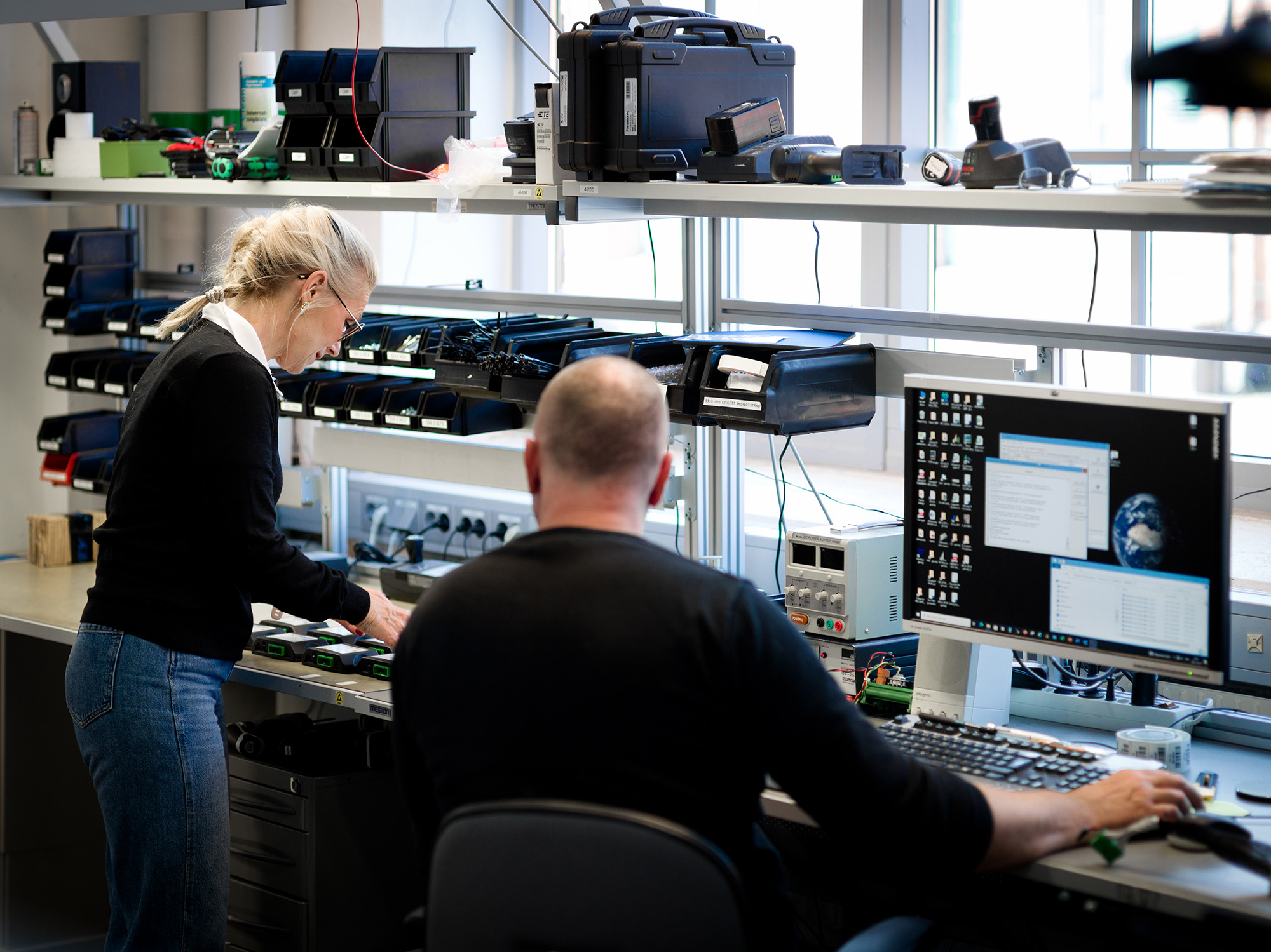 Två medarbetare arbetar vid en arbetsbänk i produktionen.