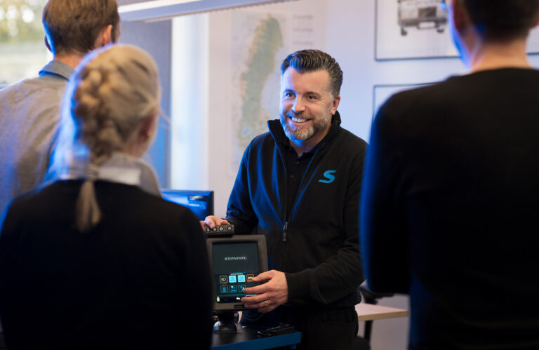 Supportmedarbetare visar produkt för några personer.