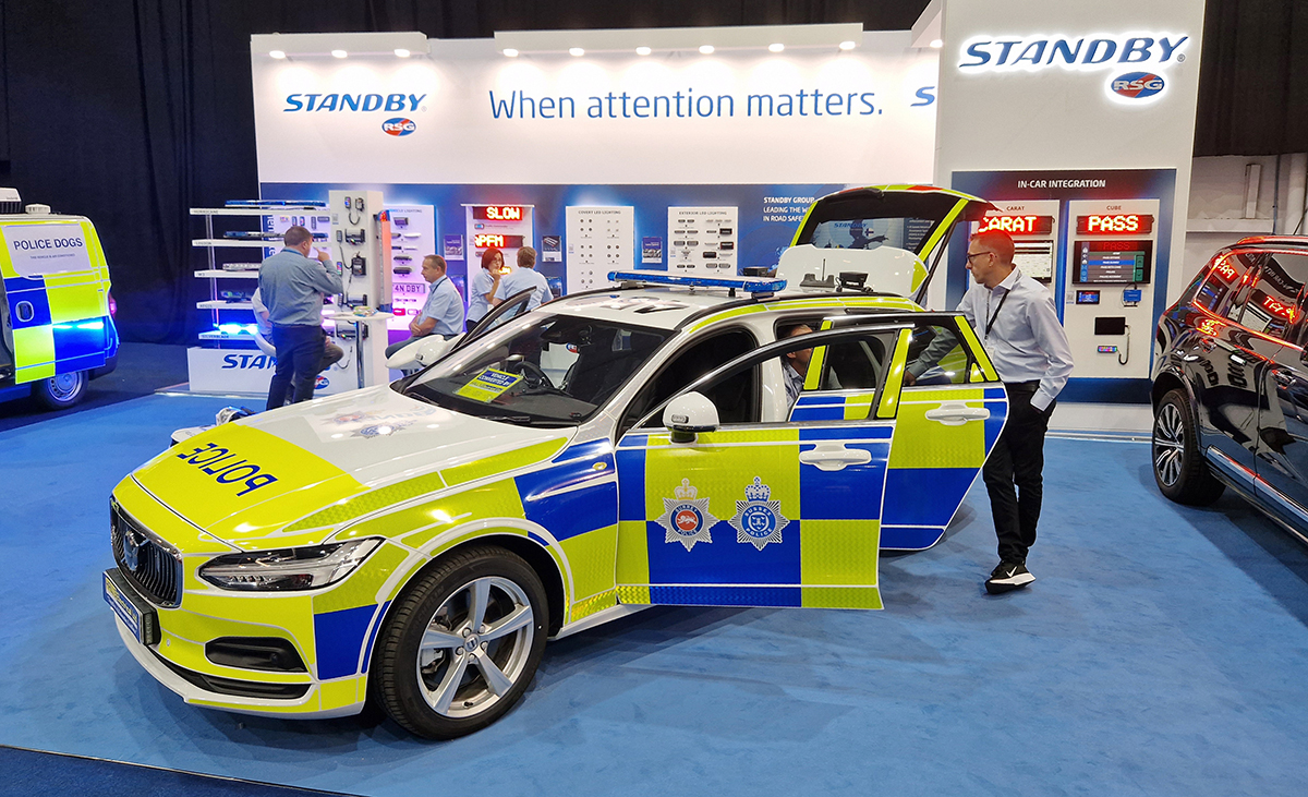 NAPFM Standby Stand Police Car, various groups of people, man leans against police car, talking to another person sitting in the back seat