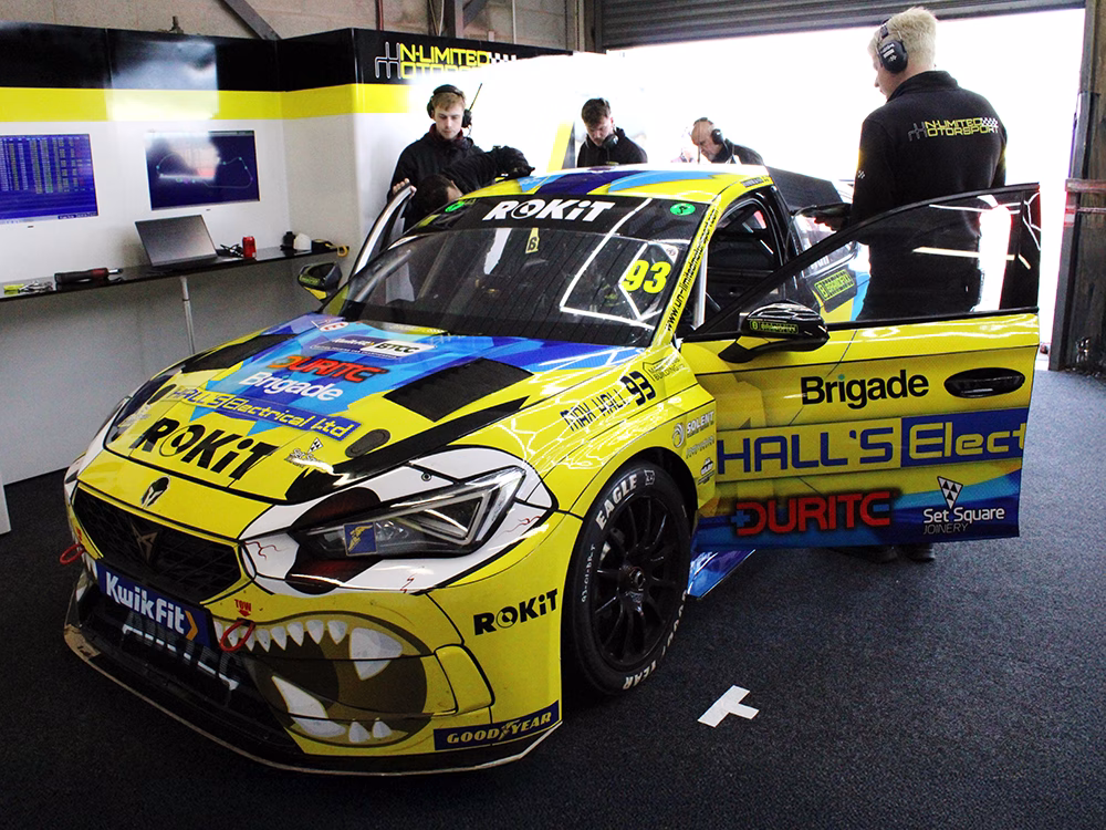 Max Hall's vehicle in the trackside garage at Donnington Park. Technicians working around it.