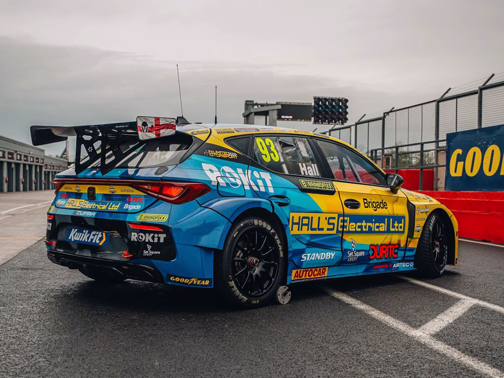 BTCC driver - Max Hall's racing car outside garage area at Donnington Park with new livery showing sponsors including Standby UK's logo shown from the reverse angle.