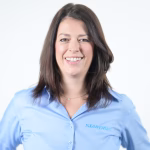 Kathrin Aster Standby Group CEO Headshot in blue shirt on light grey background.