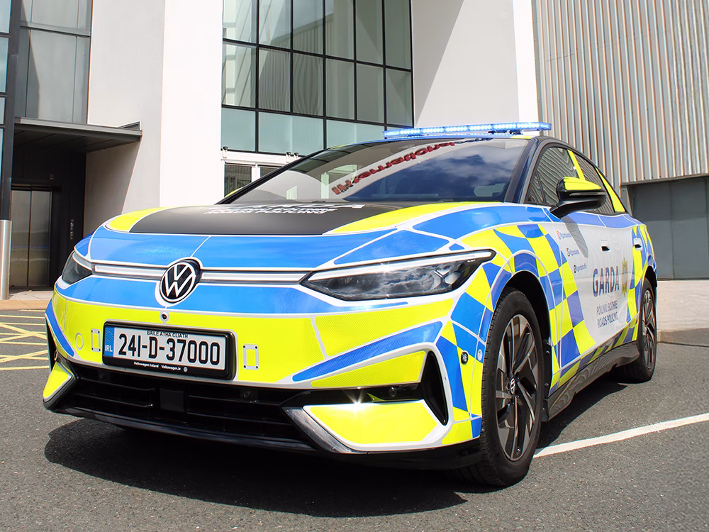 Black Garda VW ID7 with Garda livery and blue Raiden Lightbar, taken at an angle in front of Telford International Centre.