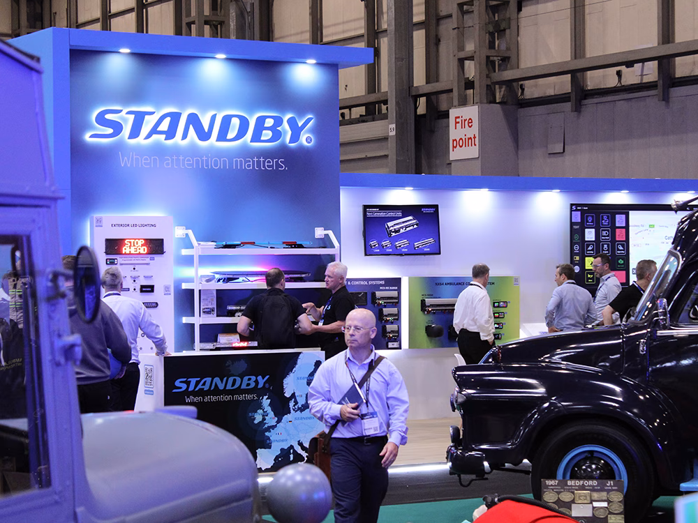 Long shot of the Standby stand at Emergency Services Show 2025 with old emergency vehicles in the foreground and lots of people on the stand