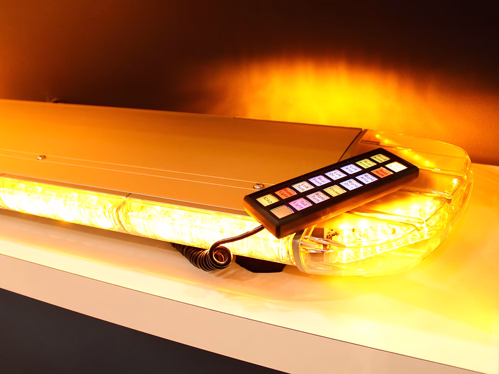 Closely cropped shot of an Amber W3 lightbar on a white shelf with the Standby T-16 handset resting at an angle on top on the Standby UK stand the Emergency Services Show 2025.