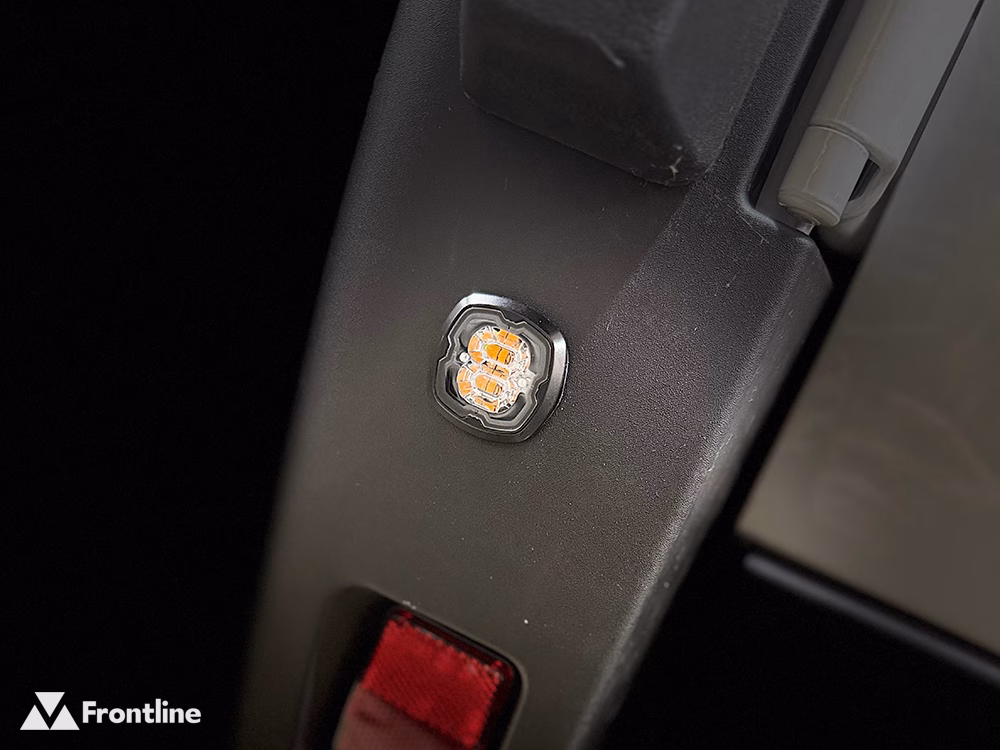 Close up of a Pop-n-Lock LED flush mounted on a black plastic vehicle component.