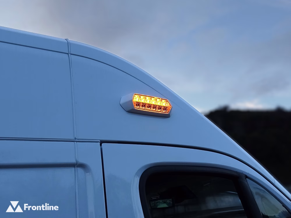 Amber SceneMax Combo LED with white bezel mounted above the driver door of a Peugeot Boxer, closely cropped and taken at dusk.
