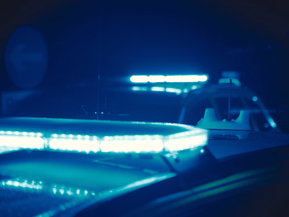 Closely cropped view of Blue Raiden Lightbars on top of staggered Police car roofs taken at night.